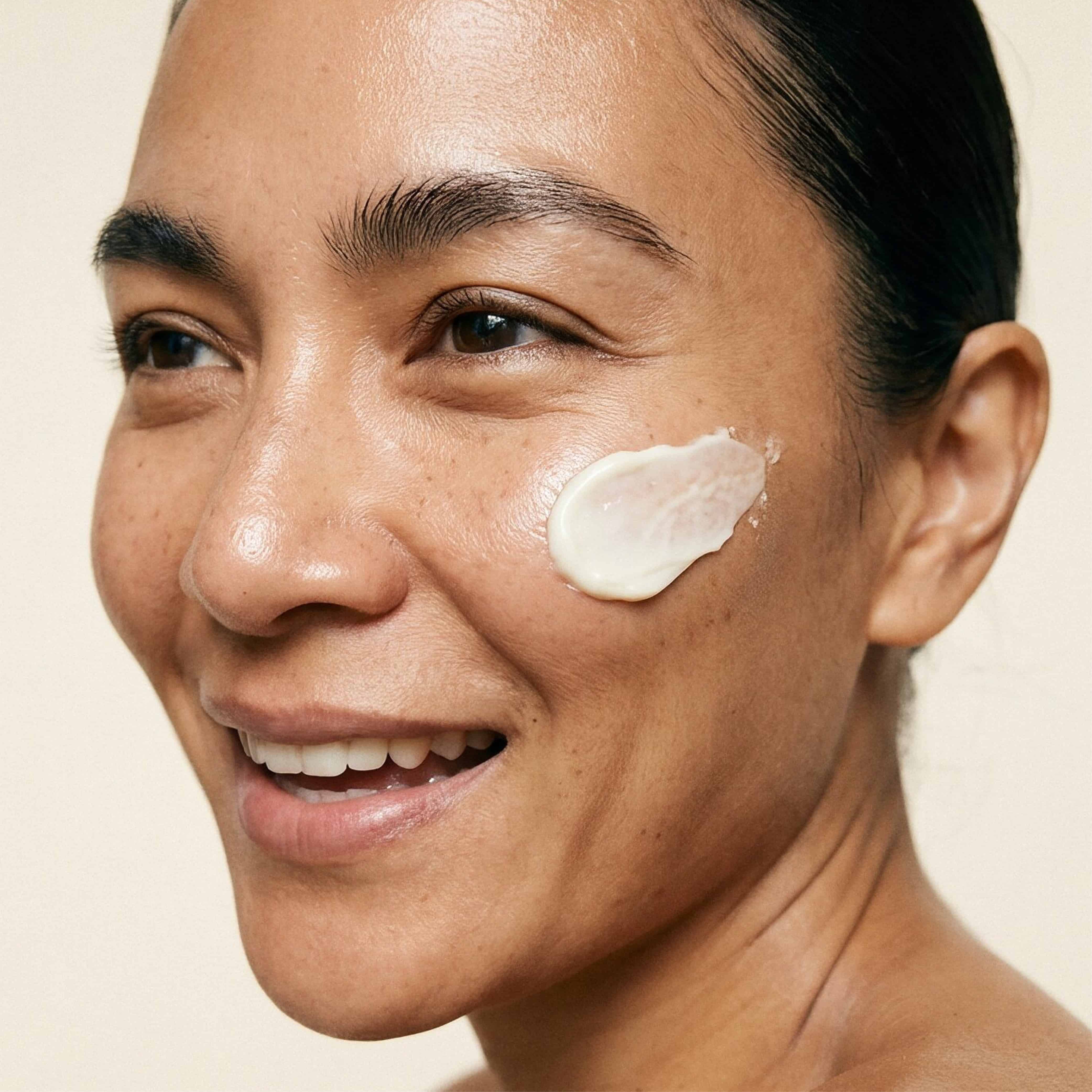 Woman with a swatch of Indie Lee Moisture Barrier Cream on her cheek