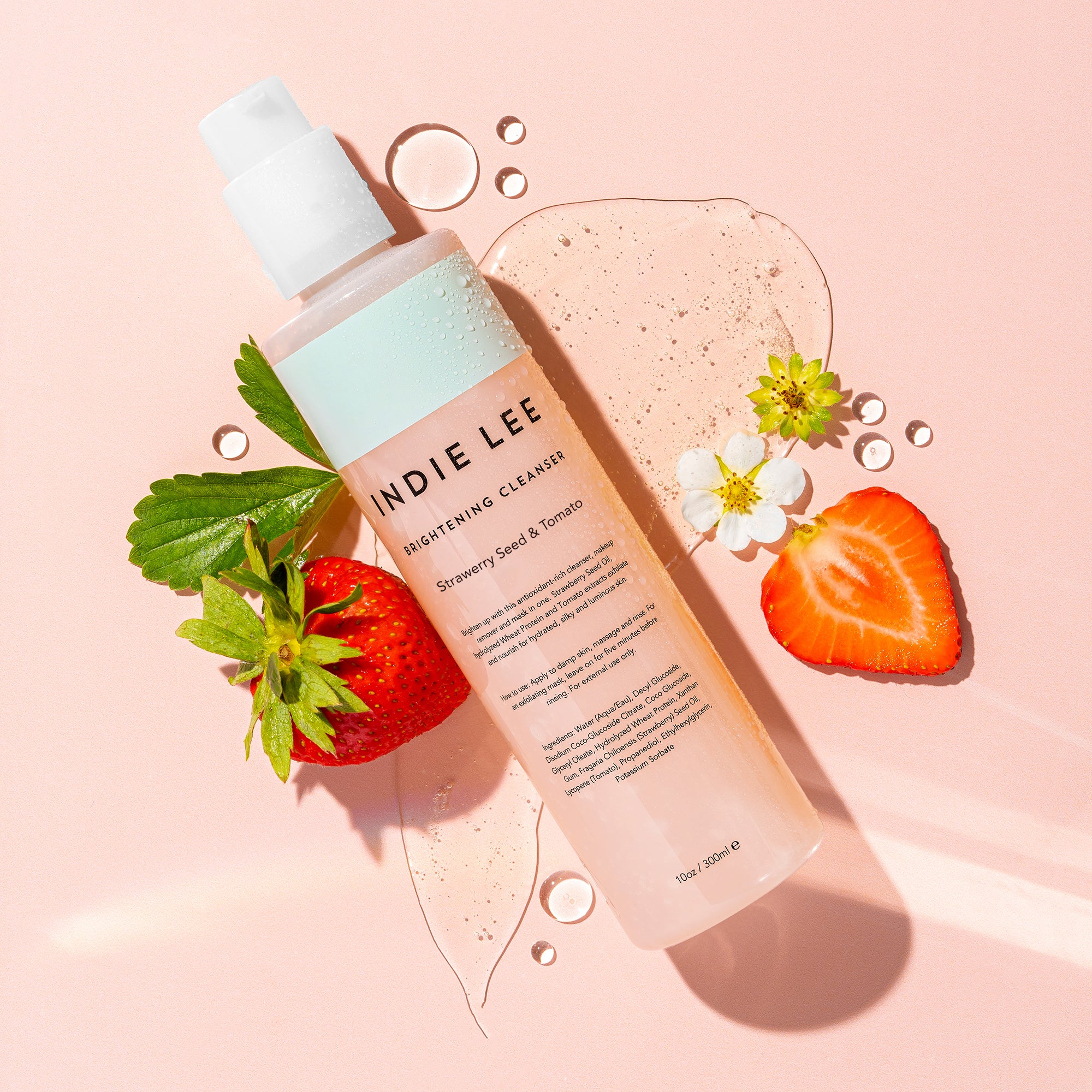Bottle of Indie Lee Brightening Cleanser on light pink background