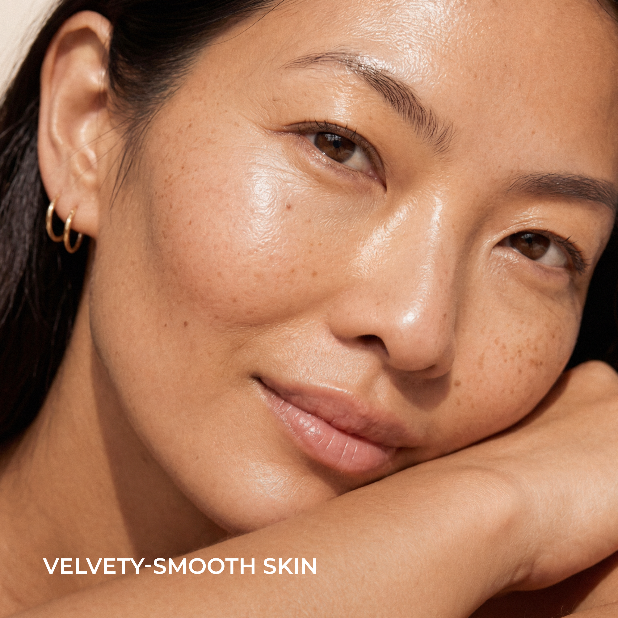 Close-up of a woman with smooth, radiant skin resting her head on her hand. Text at the bottom reads 'VELVETY-SMOOTH SKIN'.