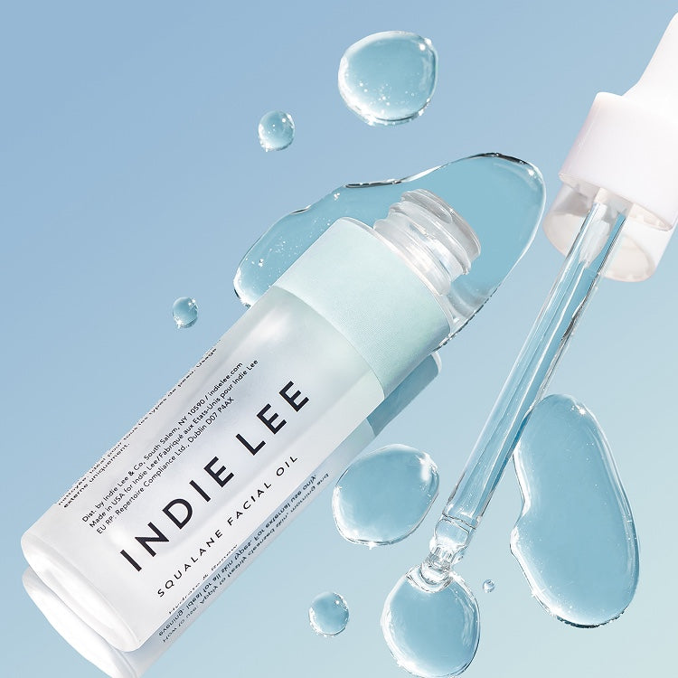 INDIE LEE Squalane Facial Oil bottle with dropper on a light blue background