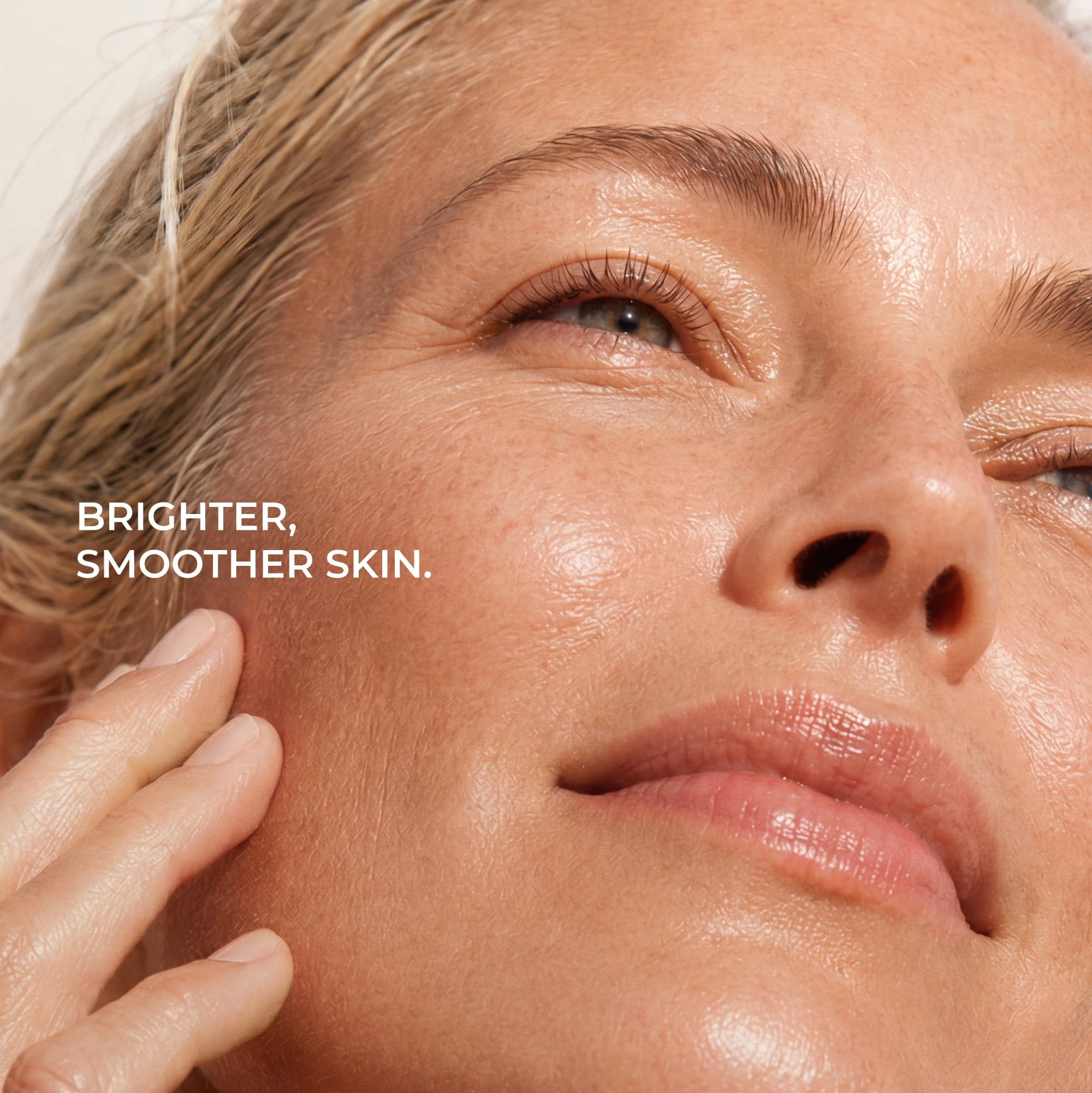 Close-up of a woman's face with text reading 'BRIGHTER, SMOOTHER SKIN.' on the left side.