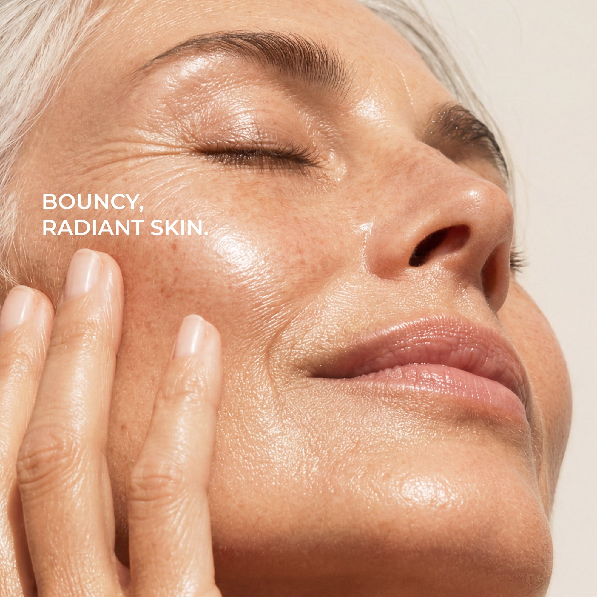 Close-up of a woman with closed eyes and her hand on her cheek, showing radiant, glowing skin. White text on the left reads 'BOUNCY, RADIANT SKIN.