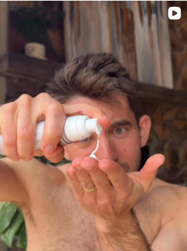 Man applying cream to his hand with a blurred background