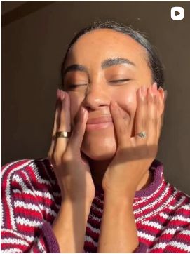 Person wearing a red and white striped sweater with hands on face